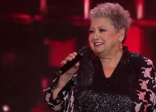 Ewa Bem na scenie podczas występu, z dynamicznym oświetleniem i wyrazistą ekspresją.