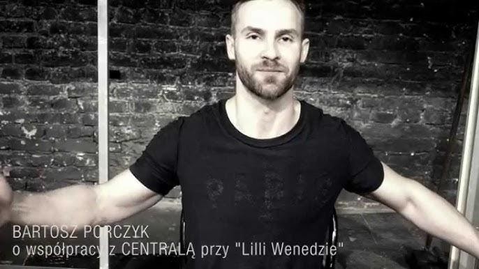Bartosz Porczyk na scenie teatralnej, w dynamicznej pozie, z teatralnym oświetleniem, oddającej atmosferę pracy aktora.
