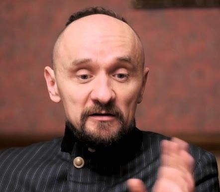 Pusta scena teatralna po spektaklu, oświetlona pojedynczym reflektorem, symbolizująca refleksję nad problemami społecznymi i politycznymi.