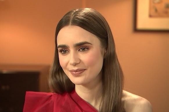 Lily Collins na planie filmowym, w kostiumie, skupiona na pracy, z elementami wskazującymi na środowisko produkcji.