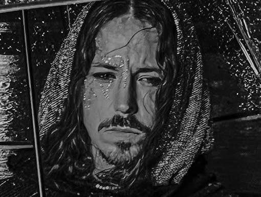 Michał Szpak śpiewający na scenie z zamkniętymi oczami, z długimi włosami, w stylowym stroju, z rozmazanymi światłami w tle.