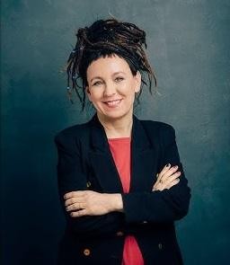 Olga Tokarczuk w zamyśleniu, w tle elementy nawiązujące do jej pracy psychoterapeutycznej i twórczości literackiej.